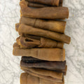 Stack of natural beef collagen dog chews on a marble surface