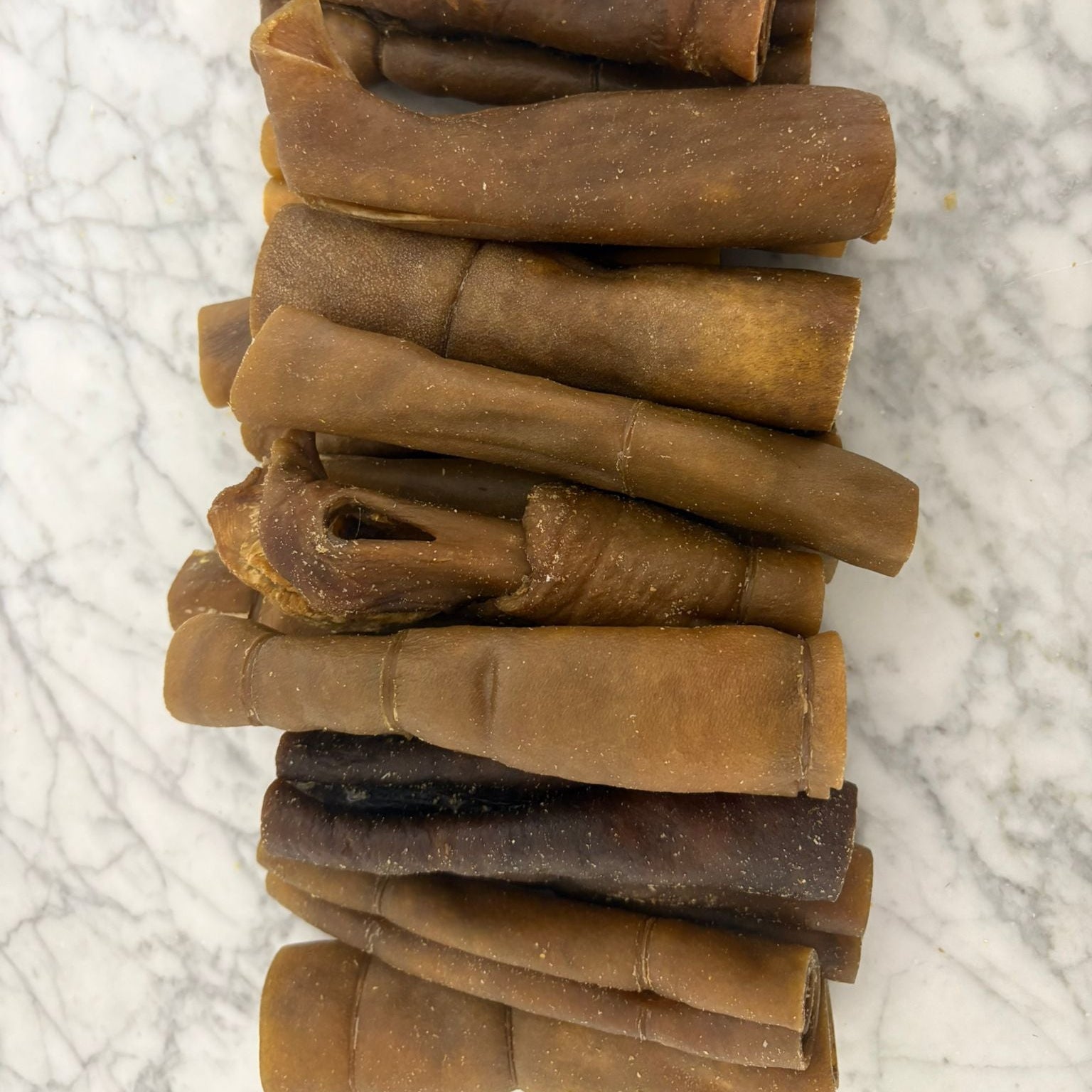 Stack of natural beef collagen dog chews on a marble surface