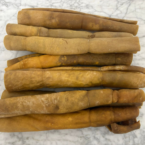 Stack of natural beef collagen dog chews on a marble surface
