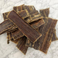 Stack of natural flat beef dog treats on a marble top